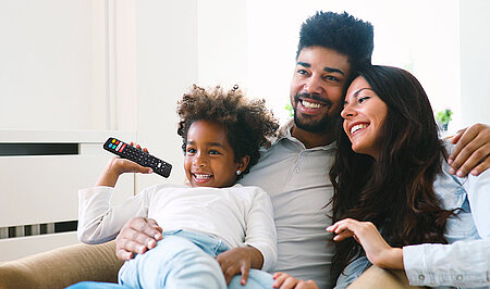 Family watching InfiniTV, featuring the InfiniTV Remote